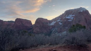 Utah, Zion Ulusal Parkı 'ndaki Kolob Kanyonları' nın karlı dağları üzerinde güzel bir gün doğumu. Ön planda çalılıklar ve renkli bir gökyüzü burayı mükemmel bir arka plan yapar.