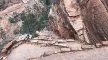 Zion Ulusal Parkı 'nda Walters Wiggles Switchback' te yürüyen birinin görüntüsü. Yol dik ve dolambaçlı, aşağıdaki kanyonun çarpıcı manzarası Utah, ABD