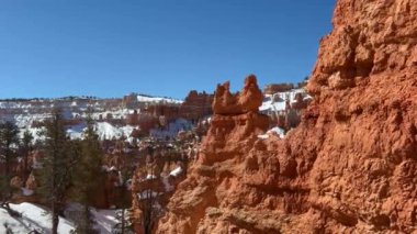 ABD 'nin Utah kentindeki Bryce Canyon Ulusal Parkı' nın kar kaplı kırmızı kaya oluşumlarının güzel bir görüntüsü. Çarpıcı kış manzarası amfitiyatronun nefes kesici manzarasını ve benzersiz kabadayılarını sunuyor.. 