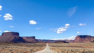 Moab, Utah yakınlarındaki Route 128 'deki Yukarı Colorado Nehri Sahne Byway' de manzaralı bir sürüşün POV görüntüsü. Güzel, vahşi batı manzarası Güneybatı destanında kızıl kayalarla çevrili..