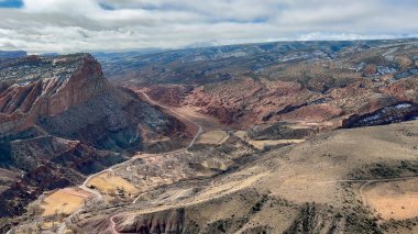 Breathtaking aerial perspective of Capitol Reef National Park, showcasing its vast desert landscapes, towering red rock cliffs, and winding canyons. The Waterpocket Fold is clearly visible - Utah, USA clipart