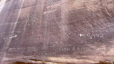 Close up of Pioneer Register names and dates carved into the sandstone of Capitol Reef National Park in Utah, USA. The carvings represent a historical register of travelers passing through the area. clipart