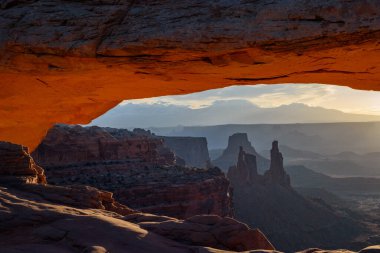 Klasik Gündoğumu manzarası Mesa Kemeri üzerinden Canyonlands Ulusal Parkı kaya oluşumlarına bakıyor ve sabah ışığı Utah, ABD
