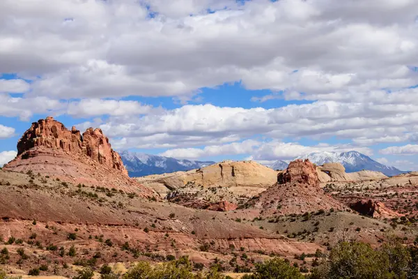 Utah 'taki Capitol Reef National Parks Waterpocket Katliamı' nın çarpıcı panoramik görüntüsü bulutlu, parlak mavi gökyüzünün altındaki kayalık manzarayı gözler önüne seriyor. Burr Trail Road - ABD