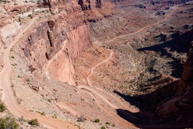 Utah, Canyonlands Ulusal Parkı 'ndaki Shafer Patikası' nın nefes kesici manzarası. Amerika 'nın bu ikonik güneybatı manzarasında dramatik uçurumlar bulunan bir araba toprak yolda ilerliyor.