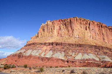 Utah, Capitol Resif Ulusal Parkı 'ndaki Waterpocket Katmanlı jeolojik kaya katmanlarının nefes kesici manzarası. Berrak mavi gökyüzü altında engebeli kaya oluşumları ve canlı renkler - ABD