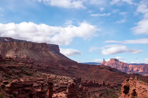 Moab, Utah yakınlarındaki Fisher Kuleleri 'nin nefes kesici manzarası. Görüntü, mavi gökyüzü altında çarpıcı kızıl kaya oluşumlarını yakalıyor ve Amerika 'nın güneybatısının dramatik ve engebeli güzelliğini gözler önüne seriyor.