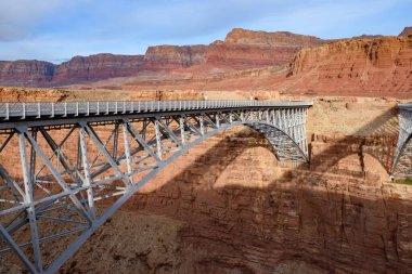 Arizona 'daki Marble Kanyonu' na yayılan Navajo Köprüsü manzarası. Arka planda dramatik Vermillion uçurumları var. Köprü, çöl manzarasına karşı mühendislik harikasını vurguluyor..
