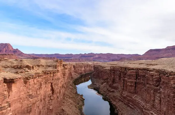 stock image Spectacular early morning view of Marble Canyon from Navajo Bridge in Arizona, showcasing the dramatic landscape of red rock cliffs and a winding river under a serene blue sky - USA