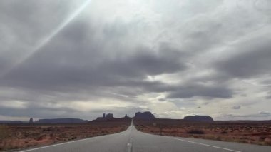 Utah, ABD 'deki Forrest Gump Point' ten ikonik Monument Valley yolu. Bulutlu ve puslu bir günde, atmosferik bir ruh haliyle çekildi. Vahşi batı ve çöl yolculuklarının sembolü..