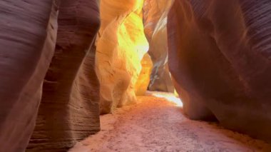 Bakış açısı, Arizona, Utah sınırındaki dar Buckskin Gulch Kanyonu 'ndan geçiyor. Yavaş çekimde çarpıcı güneybatıda yürüyüş yapma hissini yaşayın.