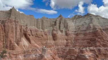 Utah 'taki Kodachrome Havzası' ndaki güzel pastel kayalıkların statik çekimi. Mavi gökyüzü ve beyaz bulutlar bu renkli kaya oluşumlarının manzaralı güzelliğini artırıyor.