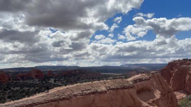 Utah 'taki Kodachrome Havzası' nda dik bir tepeye doğru yürüyen bir erkek yürüyüşçü. Vadi zemininin manzarası ve çarpıcı manzarası ile ABD