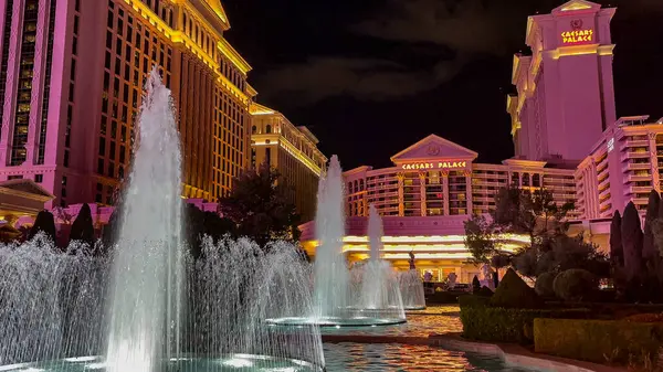 Las Vegas, Nevada, ABD - 03.25.2024: Caesars Palace Hotel ve Casino 'nun dış yüzeyi geceleyin ön planda güzel fıskiyelerle aydınlatıldı