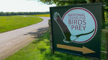 Helmsley, North Yorkshire, UK - 05.23.2023: Entrance signboard of the National Centre for Birds of Prey, situated near a scenic country road and surrounded by lush green fields. clipart