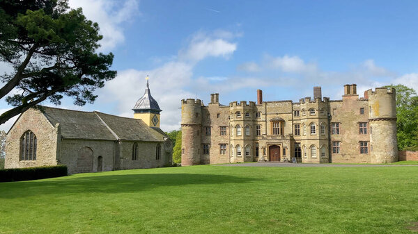 Крофт, Херефордшир, Великобритания - 14.5.2023: вид на исторический замок Крофт и прилегающую к нему церковь, расположенную в живописной сельской местности под ярким и ясным небом.