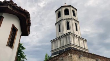 St. Constantine ve Helena Kilise Kulesi 'nin alçak açılı manzarası ve Bulgaristan' ın Filibe kentindeki bina. Arka planda bulutlu bir gökyüzü.
