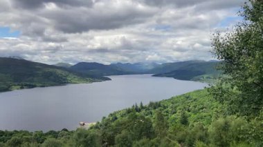 İskoçya 'daki Primrose Hill' den Katrine Gölü 'nün ve etrafındaki dağların ve ormanların manzarası. Küçük bir rıhtım görünüyor - Trossachs, İngiltere