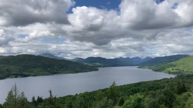 Primrose Hill 'den İskoçya' daki Katrine Gölü manzarası. Huzurlu göl yemyeşil tepeler ve bulutlu mavi gökyüzü ile çevrilidir - Trossachs, İngiltere