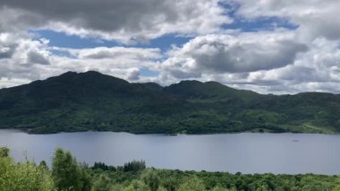 İskoçya 'daki Primrose Hill' den Loch Katrine 'in manzarası. Sakin sularda bir vapur yüzüyor. Bereketli doğa ve bulutlu gökyüzü barışçıl bir atmosfer yaratır - Trossachs, İngiltere