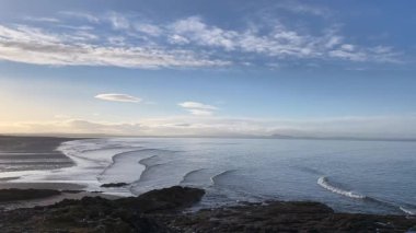 İskoçya 'daki Aberlady Körfezi' nde sakin dalgalar yavaşça kumlu kıyıya vuruyor. Huzurlu sahil sahnesinde Seton Sands sahilinin güzelliği ve gün batımında Forth Firth - Nr Aberlady, İngiltere
