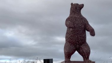 Dunbar, İskoçya, İngiltere - 01.03.2024: İskoçya 'nın Dunbar kentinde sanatçı Andy Scott' ın dev metal ayı heykeli. Dramatik gökyüzü sanat eserlerine heybetli bir atmosfer ekler..