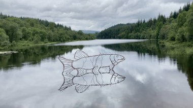 Nr Aberfoyle, İskoçya, İngiltere - 07.03.2023: Halen sakin bir günde Trossachs 'teki Queen Elizabeth Orman Parkı' ndaki Lochan Spling 'in suyunda bulunan Rob Mulholland' ın çelik telli turna balığı heykeli.