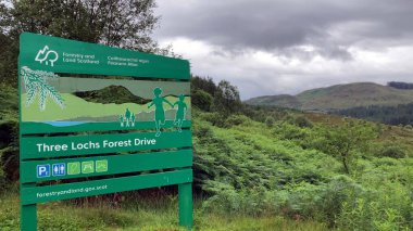 Aberfoyle, İskoçya, İngiltere - 07.10.2023: İskoçya Dağları 'ndaki üç Lochs Forest Drive tabelası. Park yerleri, tuvaletler ve piknik alanlarıyla bir aile yürüyüşü..