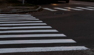 Yaya geçidinin beyaz çizgileri. Görüntünün merkezine odaklan