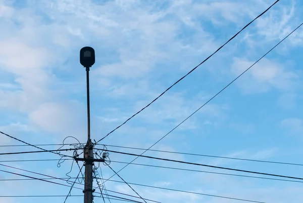 Lampstolpe Med Massa Trådar Röra Mot Grumlig Blå Himmel — Stockfoto
