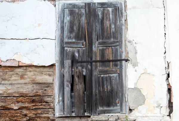 白墙上废弃旧房屋的废弃木窗百叶窗 — 图库照片