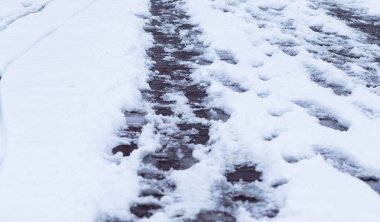 Various footprints on melting white snow