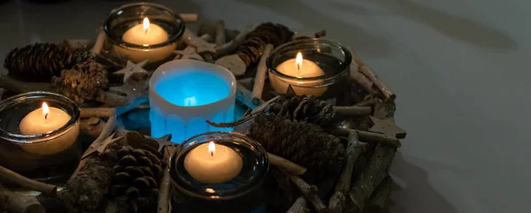 Decorative handmade installation of candles and fir cones