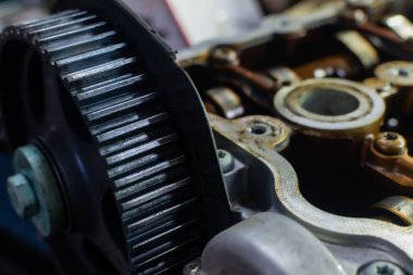 Parçalanmış motorun bulanık arkaplanındaki içten yanmalı motorun şaft dişlisi
