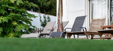 Yeşil çimenlerin ve büyük ev pencerelerinin arka planında çeşitli güneş panelleri