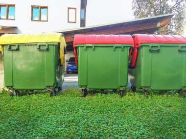 Atık yönetimi için farklı renklerde çöp kutuları, sokakta çöp geri dönüşüm kutuları