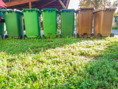 Atık yönetimi için farklı renklerde çöp kutuları, sokakta çöp geri dönüşüm kutuları