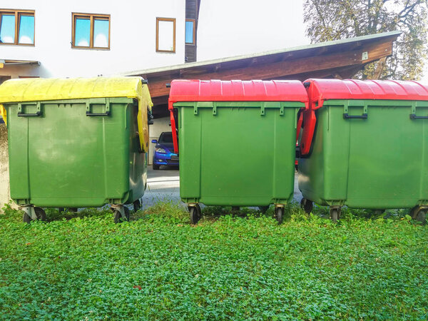 Garbage cans in different colors for waste management, trash recycling bins on the street