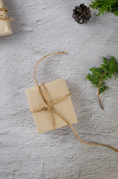 Weihnachtsstillleben Geschenkschachteln Aus Bastelpapier Und Tannenzapfen Tannenzweige Auf Grauem Grund — Stockfoto