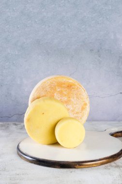 Masaya yığılmış bir yığın farklı peynir kafalar. Tahta kesme tahtasının üzerinde orta boy sert peynir kafalar. Sağlıklı organik yeme konsepti. El yapımı peynir..