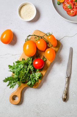 Yellow and red tomatoes on cutting board. ingredients for cooking fresh healthy vegetable salad. Summer food concept. Selective focu