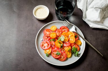 Healthy salad with red and yellow cherry tomato, sesame and parsley in plate. Summer food concept. Selective focus