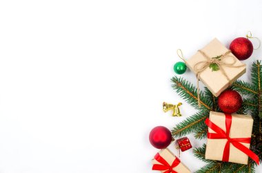 Noel süslemeleri konsepti. Üst manzara hediye kutuları el sanatları kağıdına sarılı, kırmızı mücevherler ve beyaz arka planda kurdele. Xmas kutlaması, kış tatili hazırlıkları. 