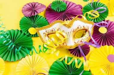 Renkli kağıt konfetileri, karnaval maskesi ve sarı arka planda fotokopi alanı, tebrik kartı ve karnaval ya da doğum günü için parti davetiye şablonu tasarımı, Mardi Gras,