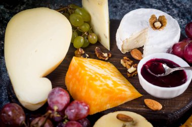 Reçelli, üzümlü, kurabiyeli, kurabiyeli, kurabiyeli ve fındıklı ev yapımı peynir. Taze süt ürünleri, peynirli atıştırmalıklar, sağlıklı organik yiyecekler. Lezzetli aperatif.