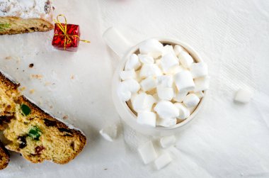 Sıcak kış içeceği. Noel sıcak çikolatası ya da marşmelovlu kakao, arkaplanda çalıntılar, noel süslemeleri ve hediye kutusu. Kış tatili kavramı.
