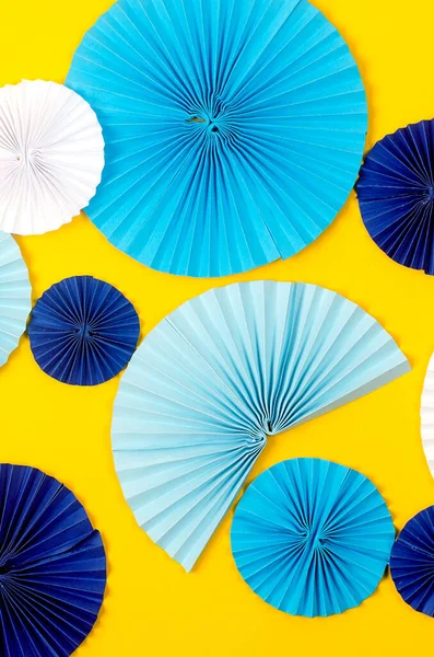 蓝纸扇形奖章 黄色背景 假期背景是Origami 摘要蓝色和黄色背景 问候卡 色彩斑斓的纸扇纸做的花 — 图库照片