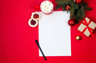 Noel Baba 'ya mektup. Kırmızı arka planda boş kağıt kağıtlarla Noel ve Yeni Yıl tatili kartı. Noel süslemeleri ve karşılama yeri olan beyaz kağıt..