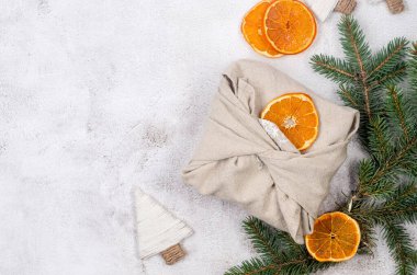 Organik kuru portakallı kumaşa sarılmış hediye kutusu. Furoshiki hediyeleri. Çevre dostu Xmas kumaşı yeniden kullanılabilir hediye sıfır atık kavramı. 