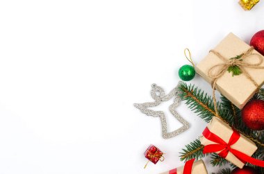 Noel süslemeleri konsepti. Üst manzara hediye kutuları el sanatları kağıdına sarılı, kırmızı mücevherler ve beyaz arka planda kurdele. Xmas kutlaması, kış tatili hazırlıkları. 